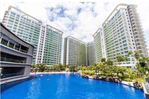 a large blue pool in front of tall buildings at Joanne Sweet Home in Manila