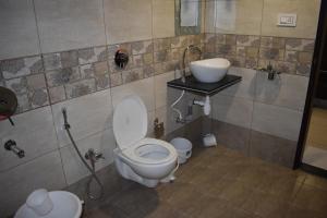 a bathroom with a toilet and a sink at Hotel Shyam Palace in Bhuj