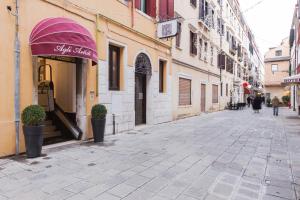 une rue vide avec un auvent violet sur un bâtiment dans l'établissement Hotel Agli Artisti, à Venise