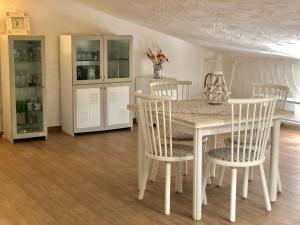 a white dining room with a table and chairs at Appartamento Leda in Piras