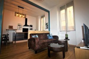 ein Wohnzimmer mit einem Sofa und einem Tisch in der Unterkunft Escale meublée in Belfort