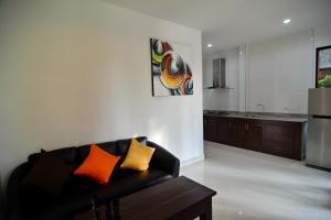 a living room with a couch and a kitchen at Arthaya Villas - SHA Extra Plus in Ko Lanta