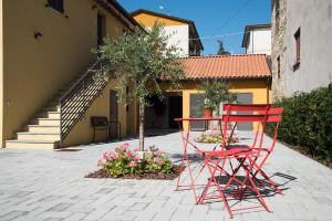 Deux chaises rouges et une table devant une maison dans l'établissement Borgo Fratta Holiday Houses, à Umbertide