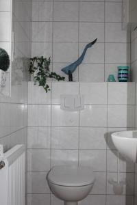 ネスマージールにあるHaus Majaのバスルーム(トイレ付)が備わります。壁に青い鳥が1羽飾られています。