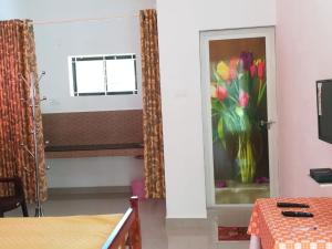 a room with a window and a vase of flowers at Kanthalloor Homestay Snow White Holiday Homes in Kanthalloor