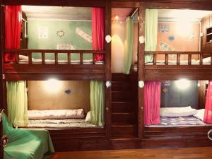two bunk beds in a room with a mirror at October Inn in Lijiang