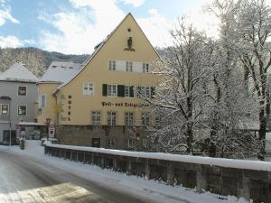 a yellow building in the snow on a street at Hotel Alpin Murau in Murau