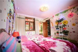 - une chambre avec un lit orné de fleurs sur le mur dans l'établissement October Inn, à Lijiang