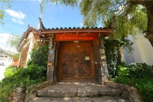 drewniane drzwi z znakiem na górze w obiekcie October Inn w mieście Lijiang