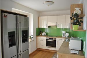 a kitchen with white cabinets and green walls at Ferienwohnung St. Martin 28 in Techelsberg am Worthersee