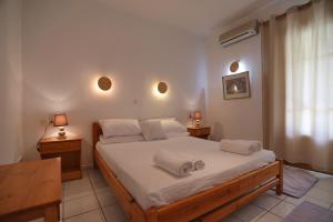 a bedroom with a large bed with white sheets at Pansion Prodromina in Skopelos Town