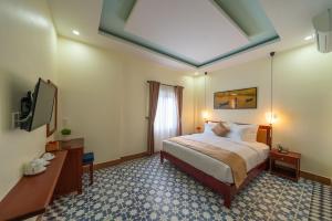 um quarto de hotel com uma cama e uma clarabóia em THE LAKE VILLA HOI AN em Hoi An