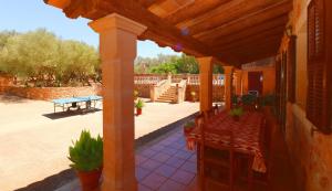 een patio met een tafel en een houten dak bij Can Guillem in Campos