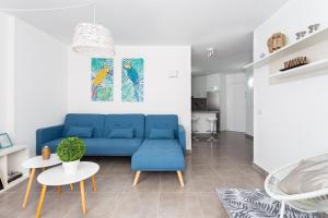 sala de estar con sofá azul y mesa en El Faro: vistas panorámicas y ubicación perfecta, en Candelaria