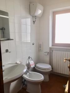 Baño blanco con aseo y lavamanos en Hotel Sporting en Roccaraso