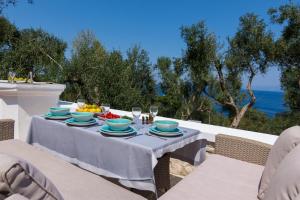 einen Tisch mit Teller mit Lebensmitteln und Meerblick in der Unterkunft PaxosBlue Suites & Villas in Gaios
