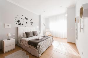 biała sypialnia z łóżkiem i oknem w obiekcie Gelvesturist w mieście Gelves