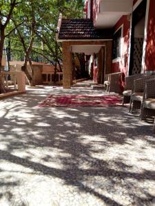 d'une terrasse avec des chaises et un tapis. dans l'établissement Hotel Ain Leuh, à Aïn Leuh