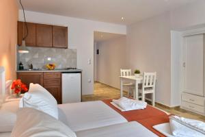 a living room with two beds and a kitchen at Hotel Korali in Troulos