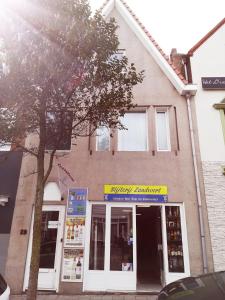 a store front of a building with a tree in front at Studio Slijterij Zandvoort in Zandvoort