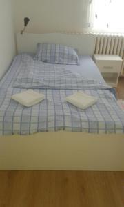 a blue and white bed with two pillows on it at A&A in Novi Sad
