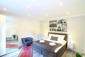 a bedroom with a bed and a blue chair at Ferienwohnung Roxana - am Bodensee in Friedrichshafen