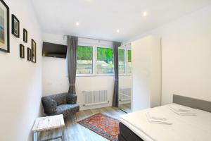 a bedroom with a bed and a chair and a window at Ferienwohnung Roxana - am Bodensee in Friedrichshafen