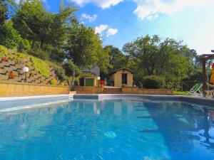 a large swimming pool with blue water in a yard at Cottage in Marche near Ski Slopes in Apecchio +31 photos