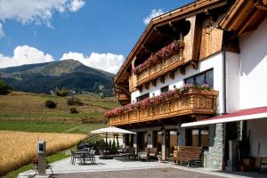 a building with a balcony with flowers on it at Alpinium - inklusive SUPER SOMMER CARD in Fiss