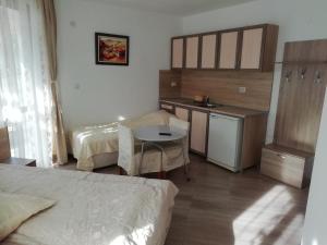 une chambre avec deux lits, une table et une cuisine dans l'établissement Iceberg, à Tryavna