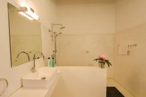 a white bathroom with a sink and a bath tub at The Araliya Retreat in Kalpitiya