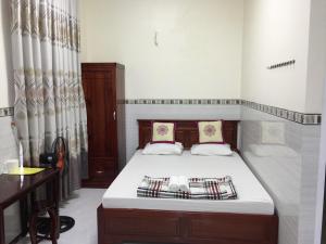 a small bedroom with a bed and a desk at Hoang Oanh Motel in Long Hai