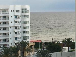 a large white building next to the ocean at Sousse Corniche Taib Mhiri Roadin Front of Riadh Palm Hotel in Sousse