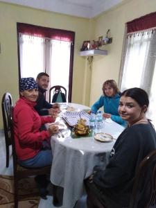 un grupo de personas sentadas alrededor de una mesa en Cool Mount Guest en Nuwara Eliya