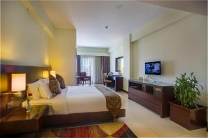 een hotelkamer met een groot bed en een bureau bij Hotel Grand Park Barishal in Barisal
