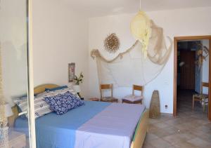 a bedroom with a bed and chairs in a room at Villa Metis in Realmonte