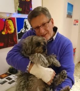 een man die een kleine hond in zijn armen houdt bij Hotel Victor Hugo Nice in Nice