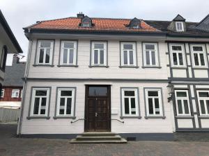 una casa blanca con una puerta marrón en una calle en Ihr Zuhause am Jakobikirchhof, en Goslar