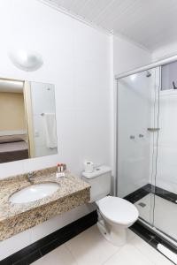 y baño con aseo, lavabo y ducha. en Hotel Express Savoy Centro Histórico en Porto Alegre