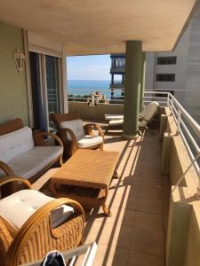 een balkon met een bank, stoelen en een tafel bij Retiro Playa y Spa in Tavernes de la Valldigna