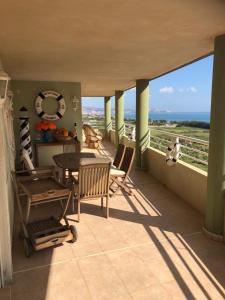een balkon met een tafel en stoelen en de oceaan bij Retiro Playa y Spa in Tavernes de la Valldigna
