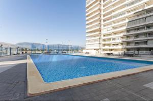 a swimming pool in front of a large building at Retiro Playa y Spa in Tavernes de Valldigna