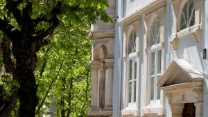 a white building with a tree in front of it at WW Hostel & Suites in Coimbra