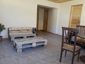 a room with two wooden benches and a chair at Irina's Guesthouse in Mestia