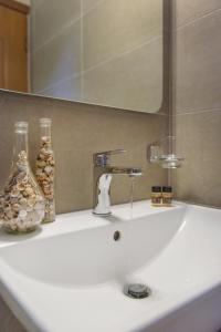 lavabo con grifo y espejo en Panorama Studios, en Ierissos