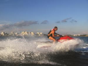 un hombre montando una moto acuática en el agua en Vittoria Immobilier 10 - REGLEMENT SUR PLACE -chèques vacances acceptés, en La Grande-Motte