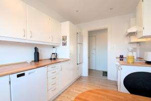 a kitchen with white cabinets and a wooden floor at Marbækvej (ID 030) in Esbjerg
