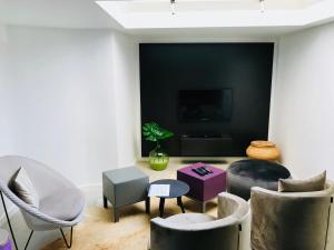 a living room with chairs and a table and a tv at LivingTheMoment in Ghent
