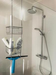 Un baño con ducha y un estante con artículos. en LivingTheMoment, en Gante