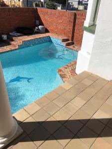 a small swimming pool with blue water in a yard at Heath Villa - private room in Port Elizabeth
